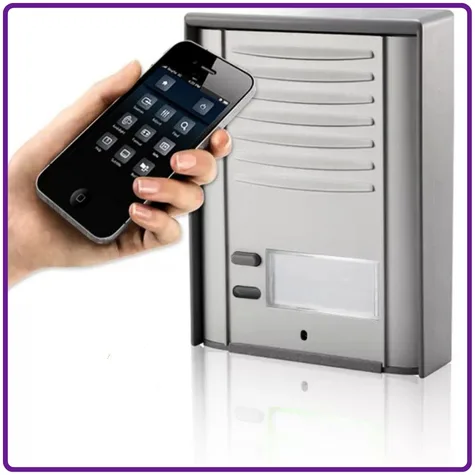 Hand holding a smartphone next to a 4G GSM access control intercom system.